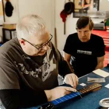 Bill, student of guitar setup mastery, setting up a customers guitar.
