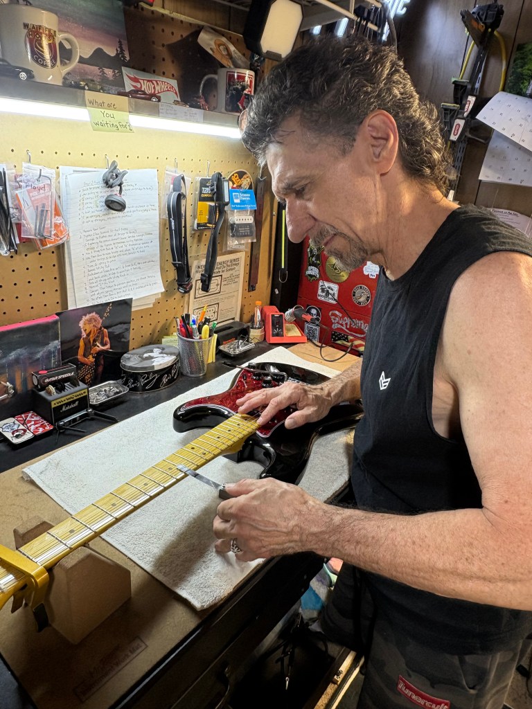 Curtis, Student of Guitar Setup Mastery, working at his home bench.