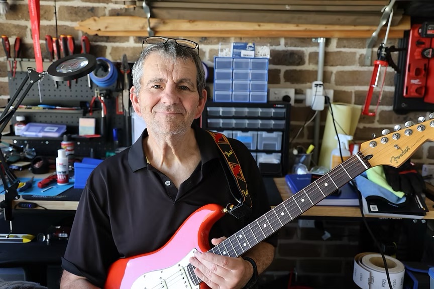 Neil, a member of Guitar Setup Mastery showing off a finished guitar.